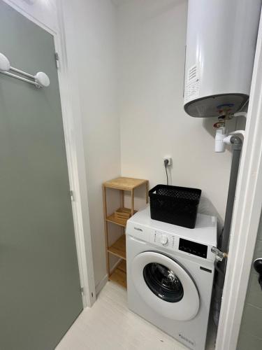 une buanderie avec un lave-linge et un four micro-ondes dans l'établissement Le nid de Mag, à Balaruc-les-Bains