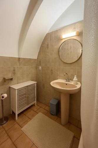 une salle de bain avec un lavabo et un miroir dans l'établissement Appartement de village proche de la plage, à Aregno
