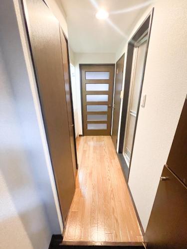 a hallway with a wooden floor and a door at パルム天神西 in Susakiuramachi