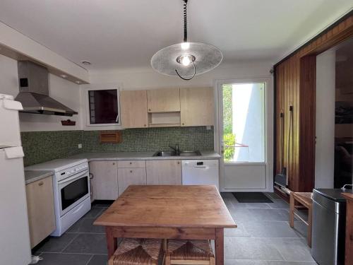 une cuisine avec une table en bois au milieu dans l'établissement Maison de charme 5 chambres, jardin central à Cauterets - FR-1-812-133, à Cauterets