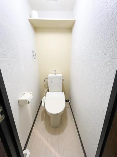 a bathroom with a toilet in a white wall at パルム天神西 in Susakiuramachi