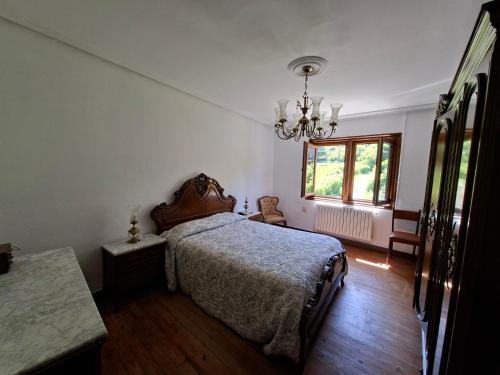 Un dormitorio con una cama y una lámpara de araña. en Casa García, Cantabria, en Pesquera