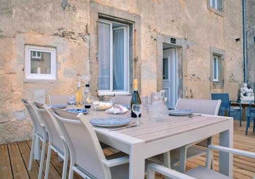 a white dining room table with white chairs and a white table and chairsktop at Le Château de La Seigne près de Carcassonne in Villemoustaussou
