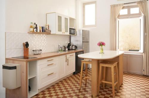 a kitchen with white cabinets and a table in it at Appartement Centre-Ville in Avignon