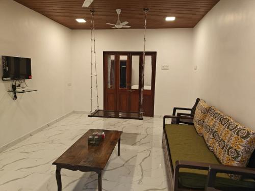 a living room with a couch and a table at The Mango Valley Nature's Stay in Alibag