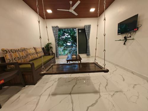 a living room with a couch and a swing at The Mango Valley Nature's Stay in Alibag