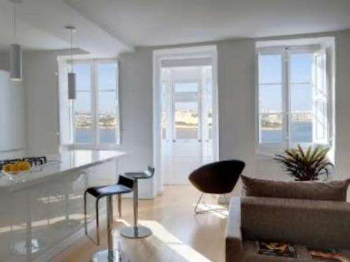 a living room with a couch and a kitchen at Valletta Seafront in Valletta