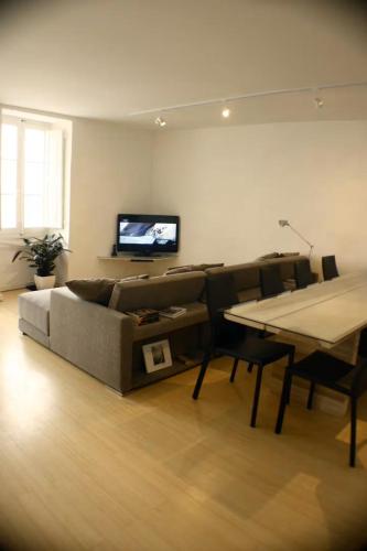 a living room with a couch and a table and a tv at Valletta Seafront in Valletta