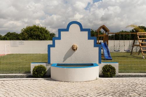 a blue and white statue in front of a playground at QUINTA das OLIVEIRAS COUNTRY HOUSE in Marinhais
