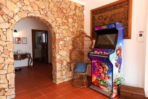 a video game arcade in a room with a stone wall at QUINTA das OLIVEIRAS COUNTRY HOUSE in Marinhais