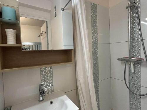 une salle de bain avec un lavabo blanc et une douche dans l'établissement Appartement 3 pièces rénové face mer - 4 personnes La Baule - FR-1-245-211, à La Baule