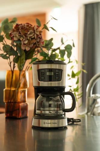 a coffee pot sitting on a table with a vase at MOVA VILLA Koshi Misawa 2 in Yuge