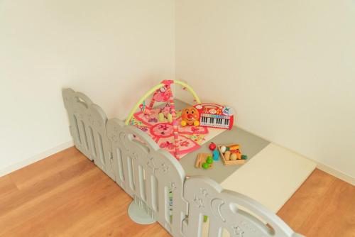 a childs room with a crib and a mirror at MOVA VILLA Koshi Misawa 2 in Yuge