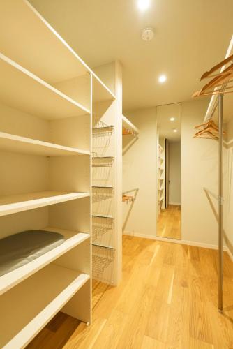 a walk in closet with white shelves at MOVA VILLA Koshi Misawa 2 in Yuge