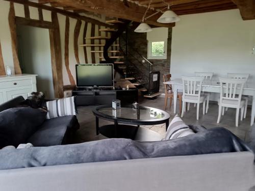 a living room with a couch and a table at Maison de Charme en Normandie in Conteville