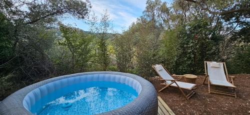 une grande piscine avec deux chaises et une piscine dans l'établissement Samadhi - Gite avec jardin et spa, à Toulon