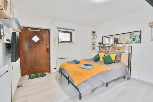 une chambre avec un lit avec une couverture orange dans l'établissement Nid du Rhin, à Ohnenheim