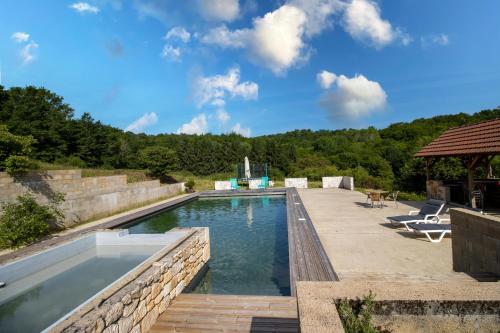 une piscine dans une cour arrière avec une table et des chaises dans l'établissement Tiny House, à Saint-Cernin-de-lʼHerm
