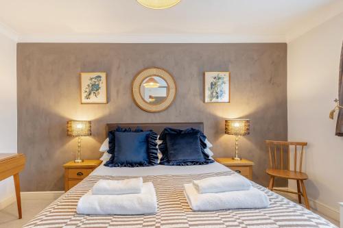 a bedroom with a large bed with blue pillows at Cornerways by Bloom Stays in Canterbury