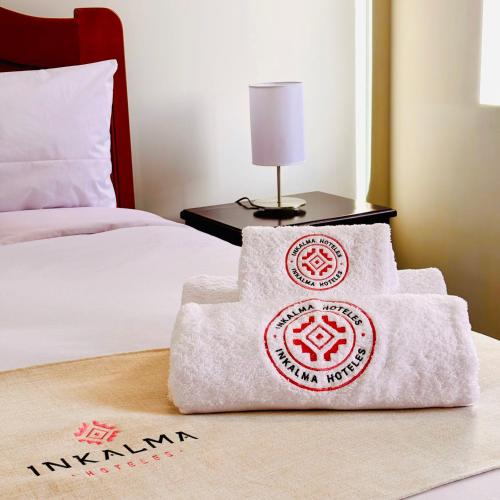 a pile of towels sitting on top of a bed at Inkalma Don Bosco in Arequipa