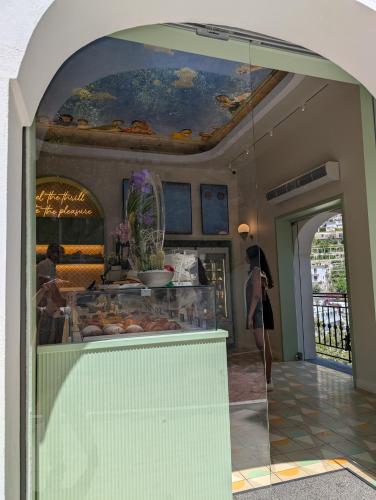 a woman is standing in front of a pastry shop at Casa Giovanna Positano in Positano