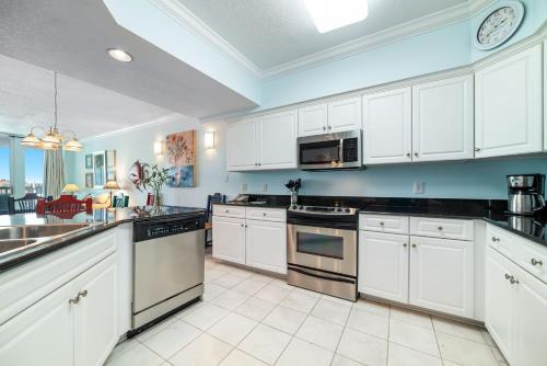 a large kitchen with white cabinets and appliances at The Pass Unit 207 in Orange Beach