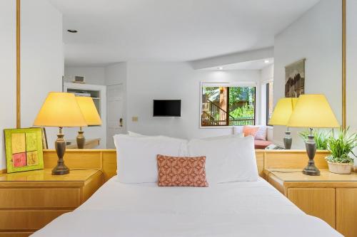 a bedroom with a white bed with two lamps at Alpine Studio at Mount Bachelor Village Resort with Pool and Hot Tub in Bend
