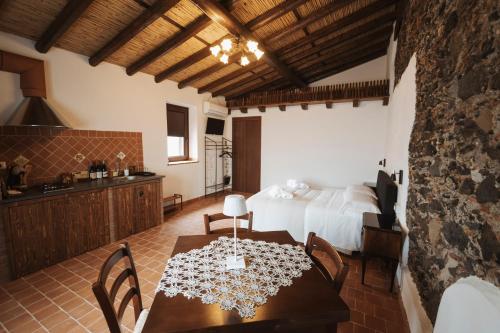 a kitchen and a bedroom with a table and a bed at CONVIVIUM - Suites Apartments in Randazzo