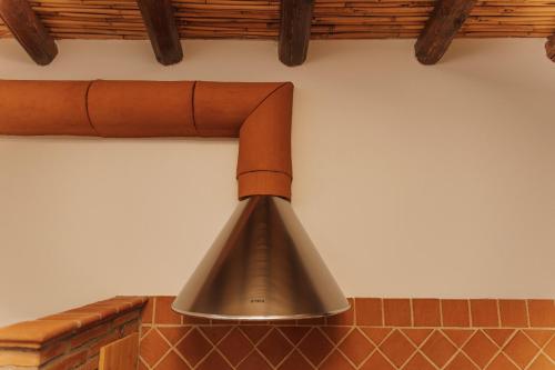 a metal pot hanging on a wall at CONVIVIUM - Suites Apartments in Randazzo