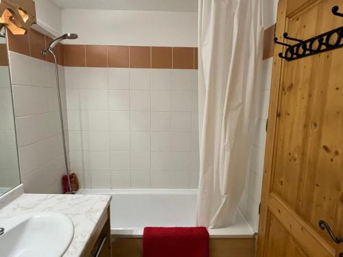 une salle de bain avec une baignoire blanche et un lavabo dans l'établissement Charmant 2 Pièces Cabine avec Parking et Balcon - Résidence Le Grand Tétras à Samoëns - FR-1-629-105, à Samoëns