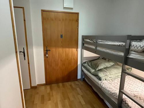 Cette chambre comprend 2 lits superposés et une porte. dans l'établissement Charmant 2 Pièces Cabine avec Parking et Balcon - Résidence Le Grand Tétras à Samoëns - FR-1-629-105, à Samoëns