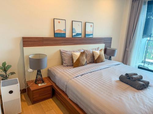 a bedroom with a large bed with a wooden headboard at The Astra Luxury Condo near old town in Chiang Mai