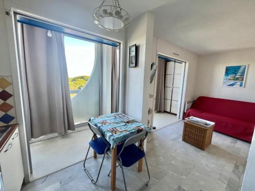 un salon avec un canapé rouge et une table dans l'établissement Studio Lumineux avec Terrasse et Parking Privé, à 600m de la Plage - FR-1-716-76, à La Grande Motte