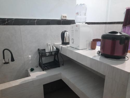 a kitchen with a counter top with a appliance on it at Ayunda Stay & Hostel in Airsatang