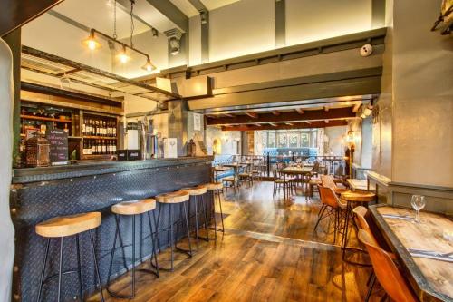 a restaurant with a bar with wooden tables and chairs at Walworth Castle Hotel, BW Signature Collection in Darlington