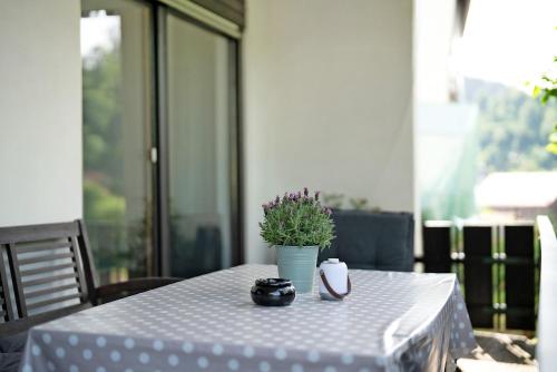 a table with a white table cloth and a potted plant at Ferienwohnung Am Lehen Schiltach in Schiltach
