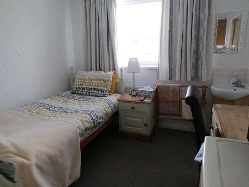 a bedroom with two beds and a sink and a window at HP Bed and Breakfast in Congleton