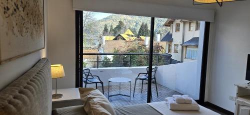 a bedroom with a bed and a view of a balcony at Ruka 7- Andarlibre in San Martín de los Andes