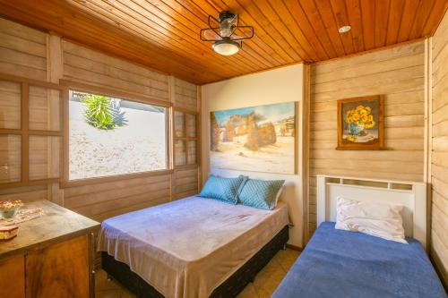two beds in a room with wooden walls at Chácara Temporada Lazer Piscina Amparo Net 200 Mb! in Amparo