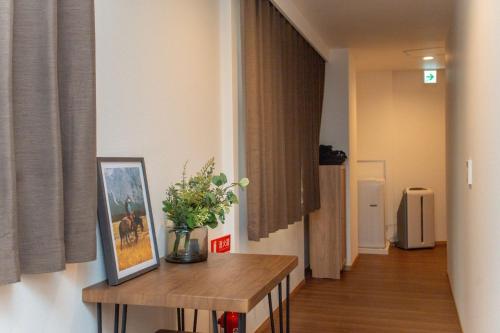 a hallway with a table with a picture and flowers on it at Natsumiホテル 高级独栋别墅301 in Tokyo