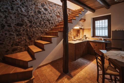 a kitchen with a staircase and a dining room with a table at CONVIVIUM - Suites Apartments in Randazzo