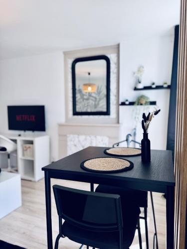 une table noire avec deux chaises et un lavabo dans l'établissement Logement Moderne au cœur de la ville, à Quimper