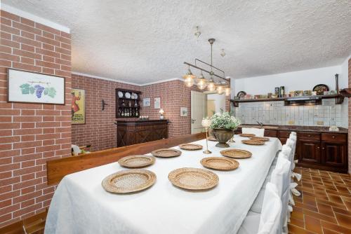 a long table with plates on it in a kitchen at Villa Edy Barbaresco con piscina per gruppi e famiglie in Barbaresco