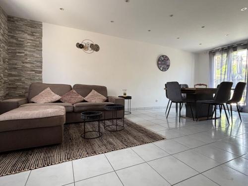 un salon avec un canapé et une table dans l'établissement Jolie Colombe, maison 3 ch 2 sdb beau jardin terrasse aménagée à 15 mn à pied de la mer et centre Port en Bessin proche Omaha Beach et Bayeux, à Port-en-Bessin-Huppain