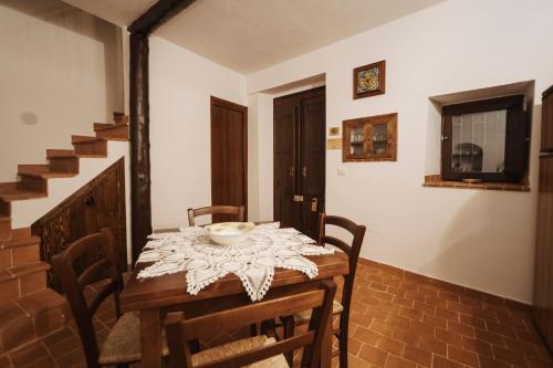 a dining room with a table and chairs and stairs at CONVIVIUM - Suites Apartments in Randazzo