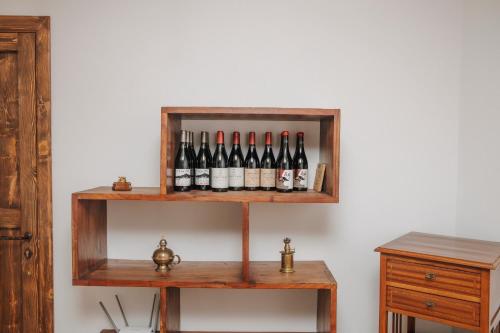 a shelf with bottles of wine on a wall at CONVIVIUM - Suites Apartments in Randazzo
