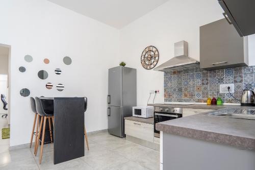 a kitchen with a refrigerator and a counter top at Large Studio Penthouse with 2 terraces - By Solea Holiday Homes in Il-Gżira