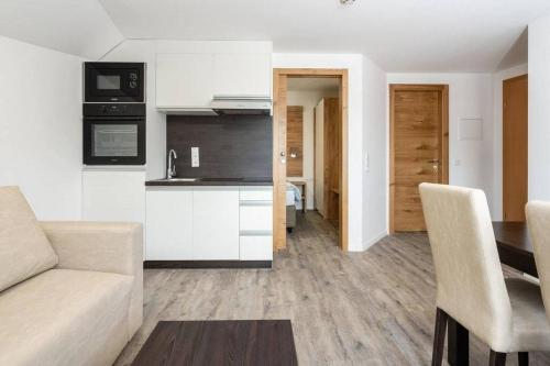 a kitchen and living room with a couch and a table at Apartments Maiskogelblick in Piesendorf
