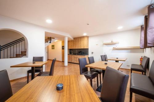 a dining room with wooden tables and chairs at Apartments Maiskogelblick in Piesendorf