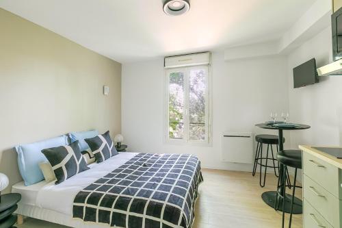 une chambre avec un lit, une table et une fenêtre dans l'établissement Studio lumineux à deux pas des commerces- Asnières, à Asnières-sur-Seine